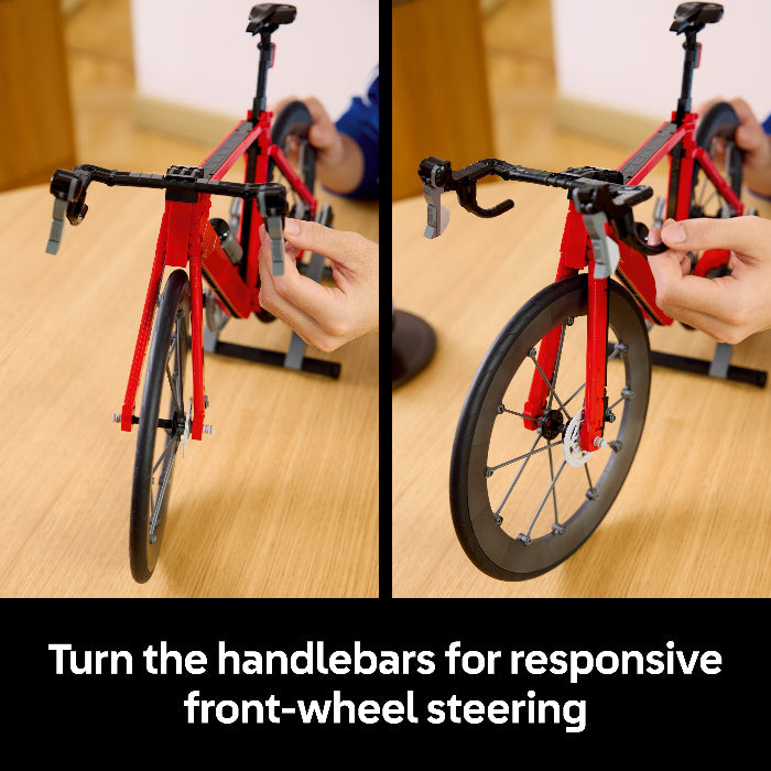 Model bicycle with front-wheel steering mechanism on a wooden surface.
