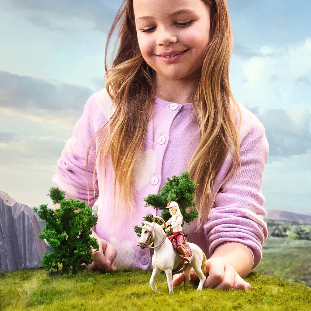 Young girl playing with a toy horse and rider in a fantasy landscape