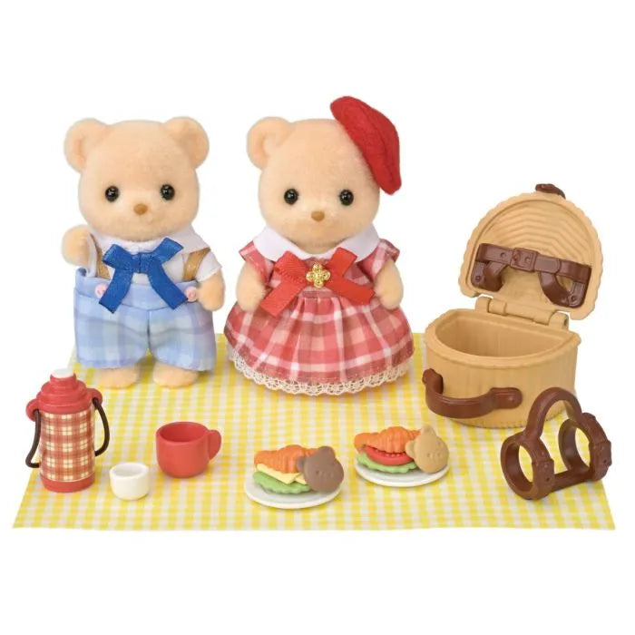 Toy bear couple with picnic setup on a white background