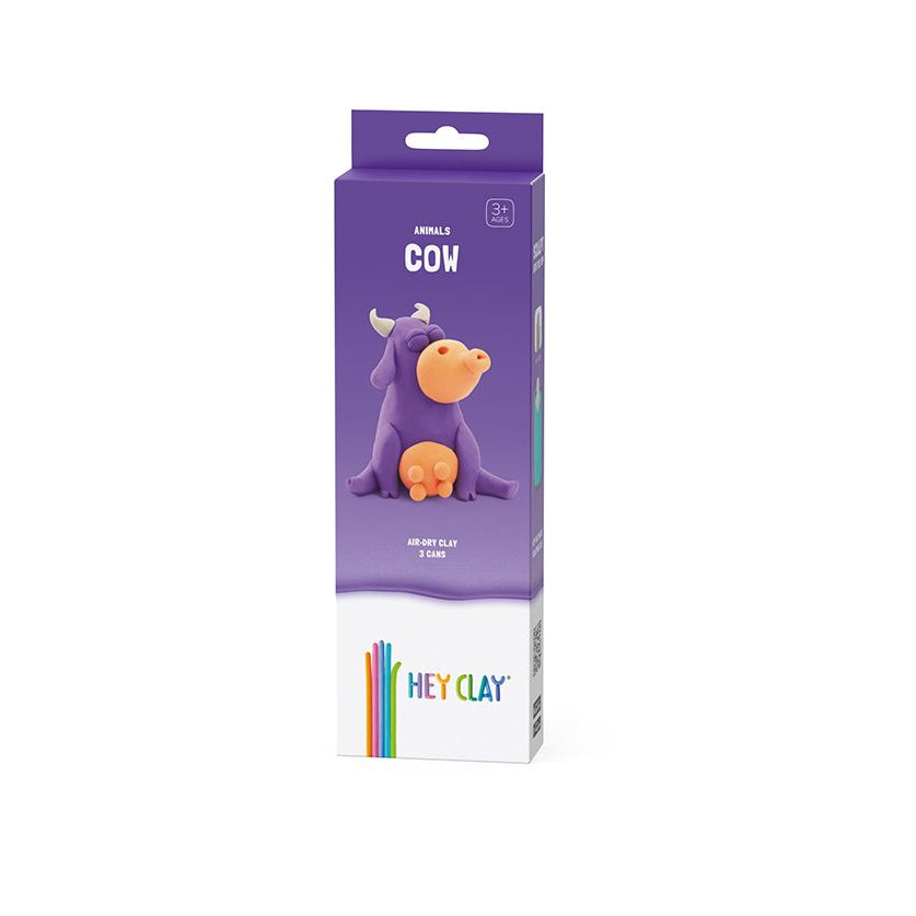 Purple packaging of Hey Clay cow figurine on a white background