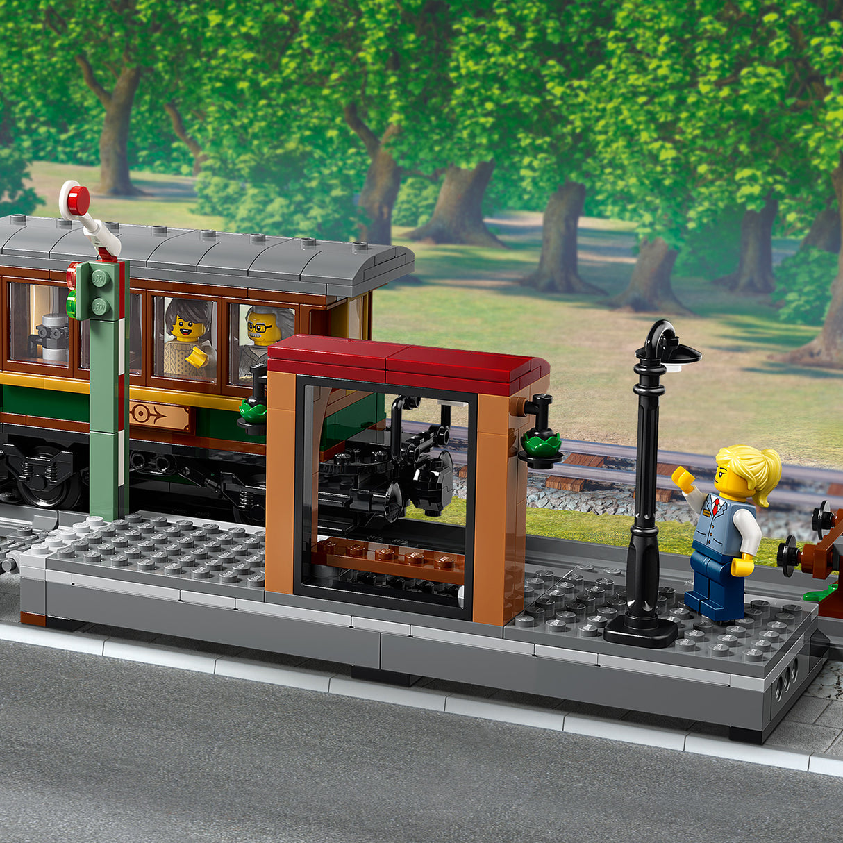 LEGO train set with a station platform and trees in the background