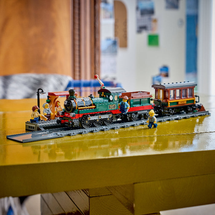 Toy train set on a yellow surface with a blurred indoor background