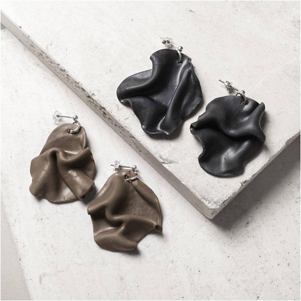 Pair of black and brown earrings on a light gray surface