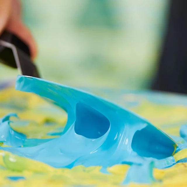Blue Liquitex Heavy Body Acrylic Paint being mixed with a yellow colour with a painting knife