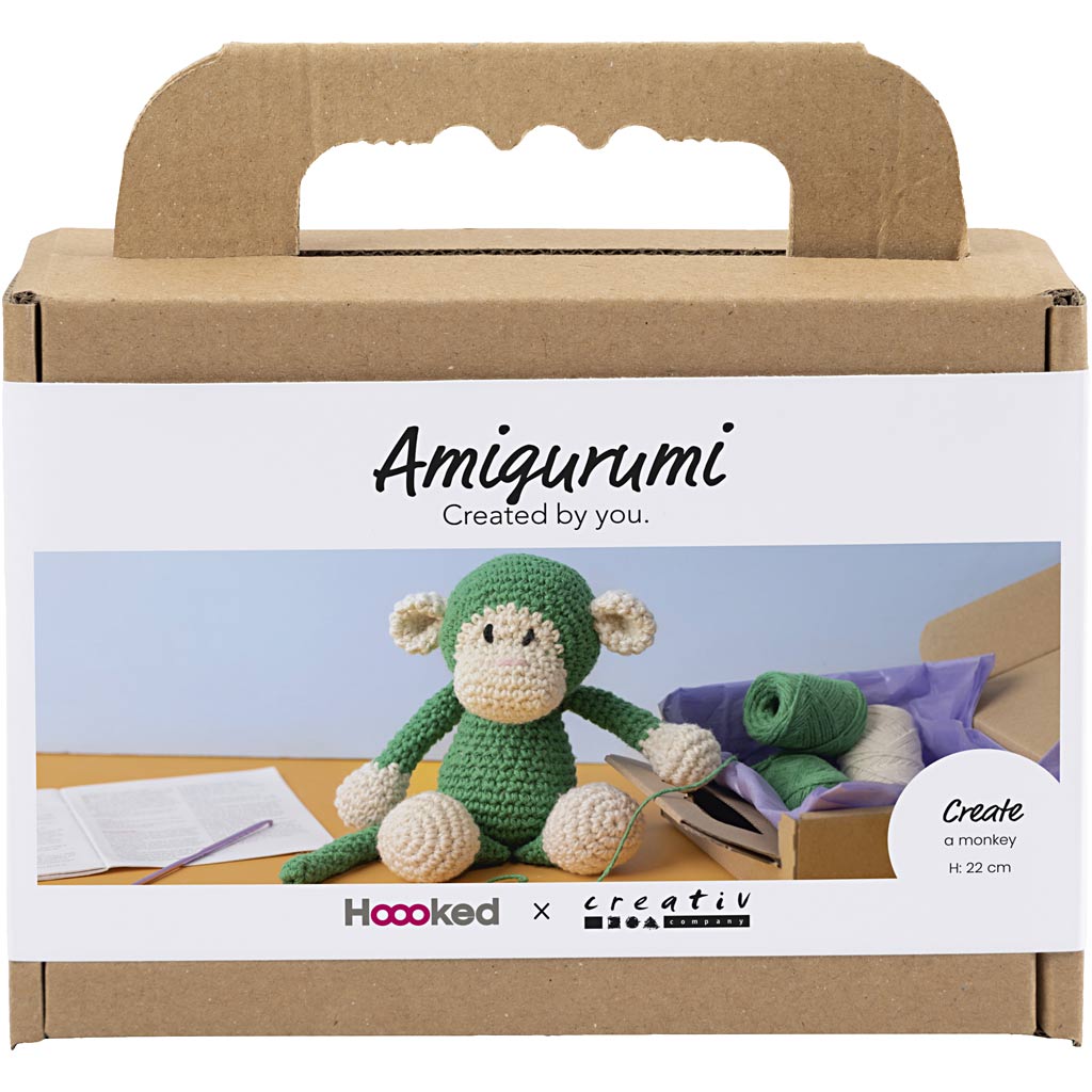 Amigurumi monkey kit packaging with cardboard box and green monkey toy inside