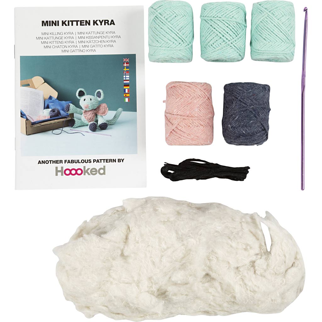 Knitting kit with yarn, needles, and pattern book on a white background