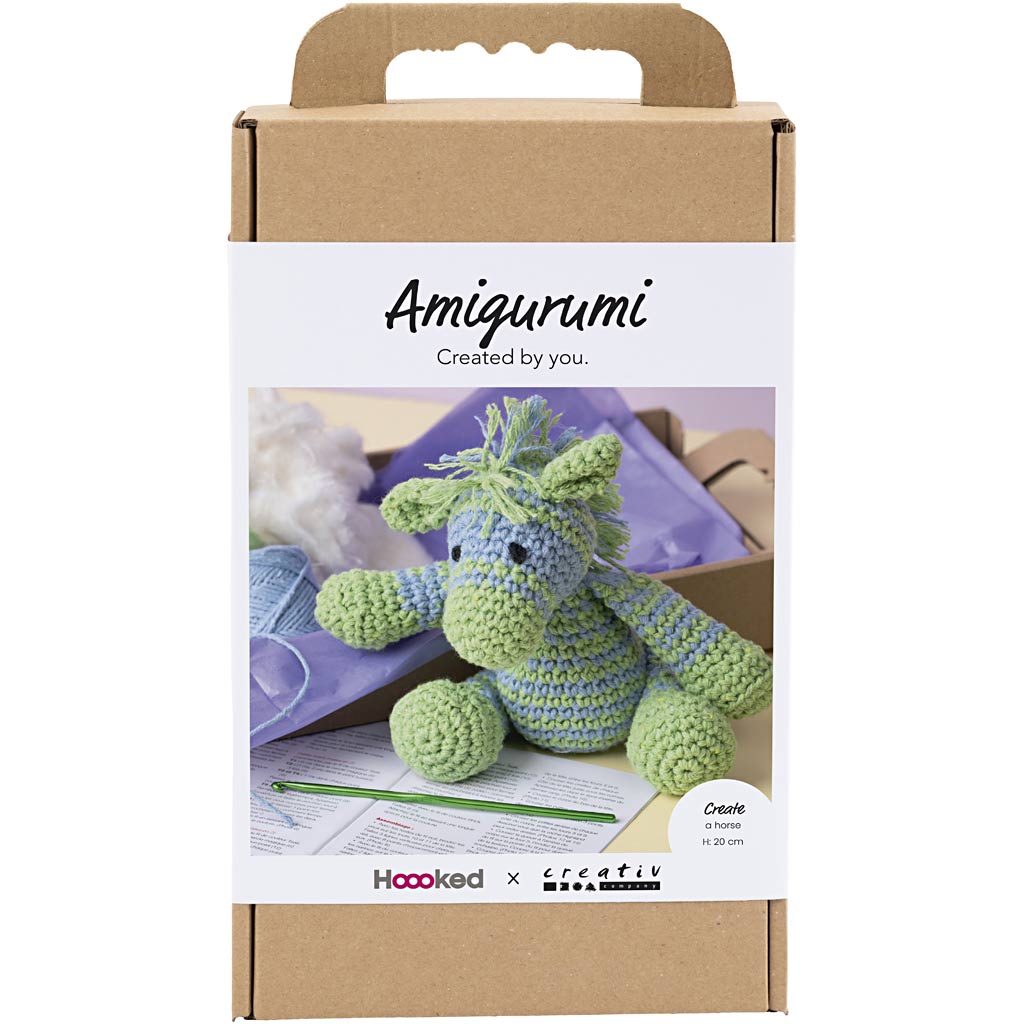 Amigurumi crochet kit packaging with a green and blue plush toy, hoop, and yarn on a white background.
