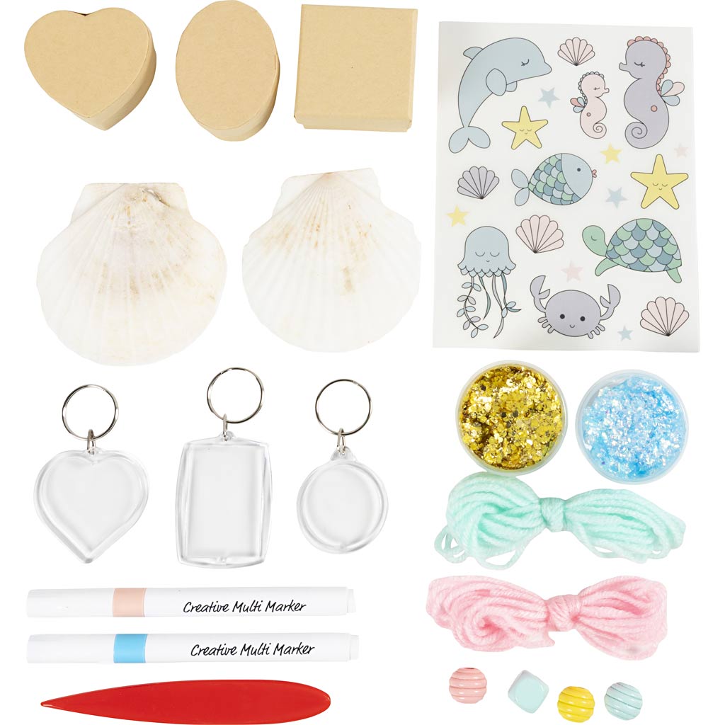 Collection of craft items including pom-poms, keychains, and stickers on a white background