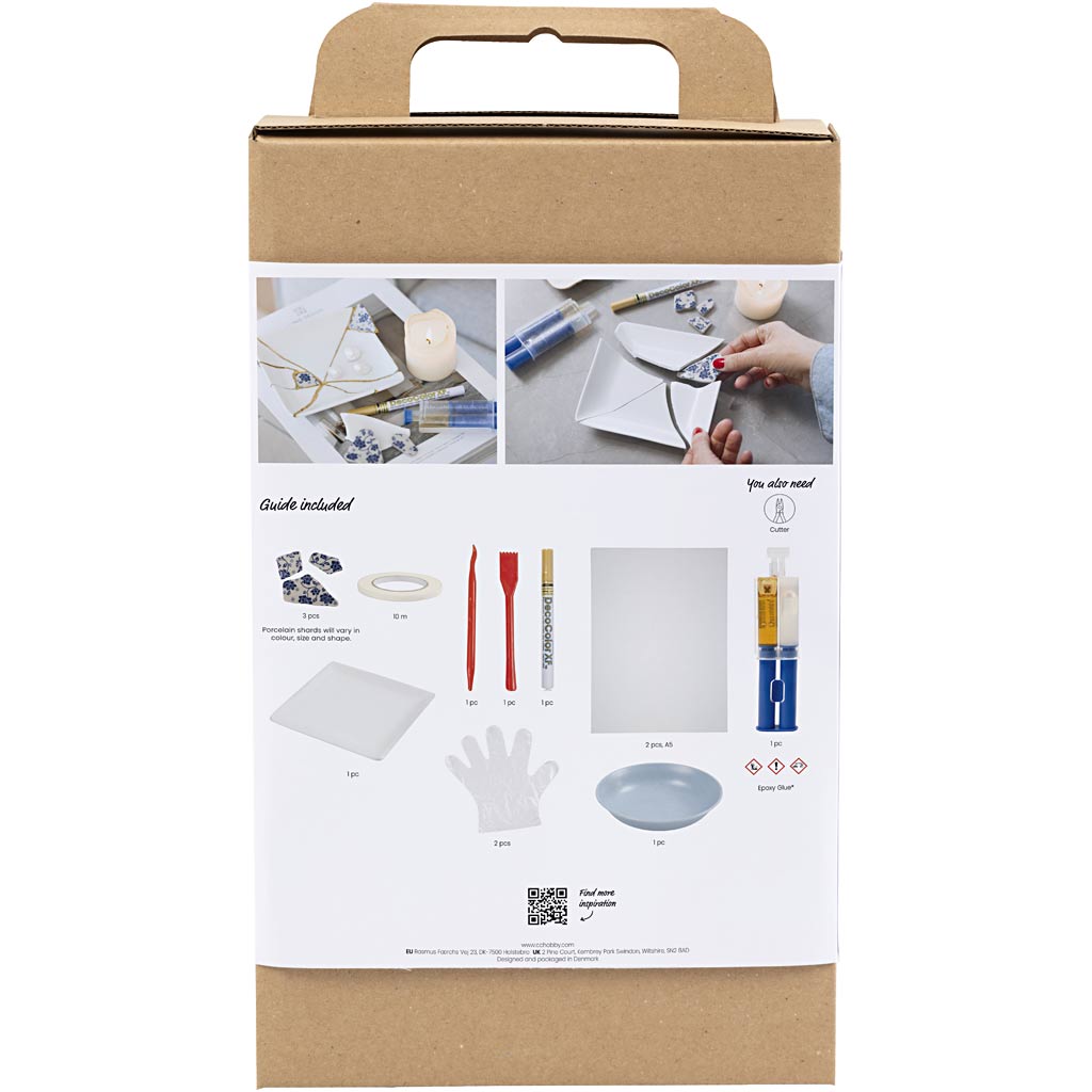Cardboard box with kintsugi craft materials and tools on a white background