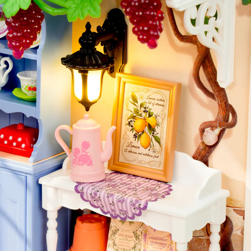 Decorative setup with a pink teapot, framed picture, and colorful background