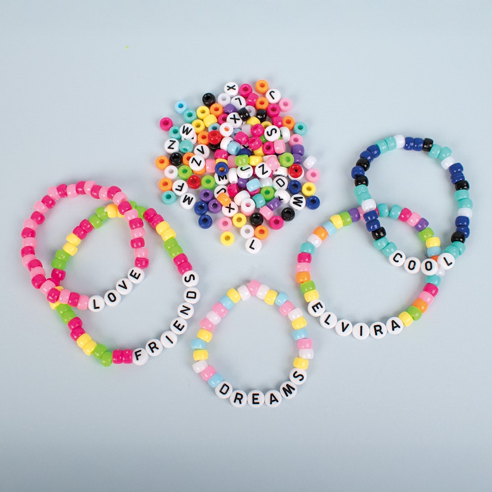 Colorful beaded bracelets with letter beads on a light gray background