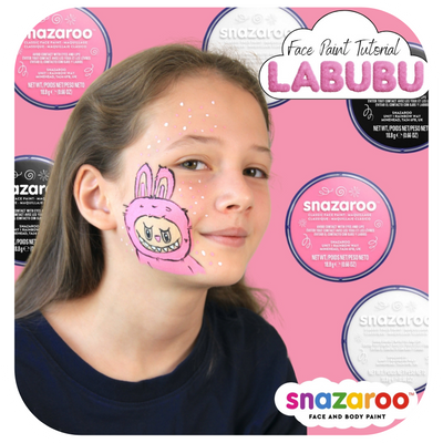 A girl with a pink labubu monster painted on her face on a pink background with Snazaroo face paint pots