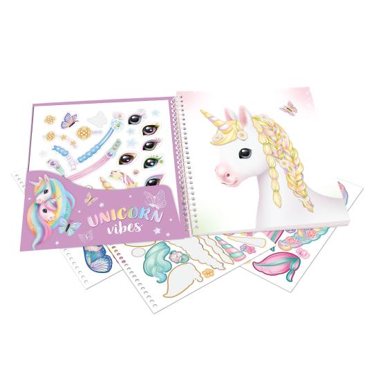 Unicorn-themed stationery set with notebook, stickers, and pen on a white background