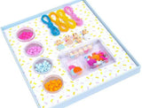 Colorful jewelry-making kit with beads and strings on a white background