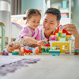 Man and young girl playing with colorful building blocks in a room.
