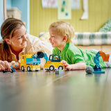 Woman and child playing with toy construction vehicles on a table
