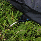 black trampoline cover being anchored into grass