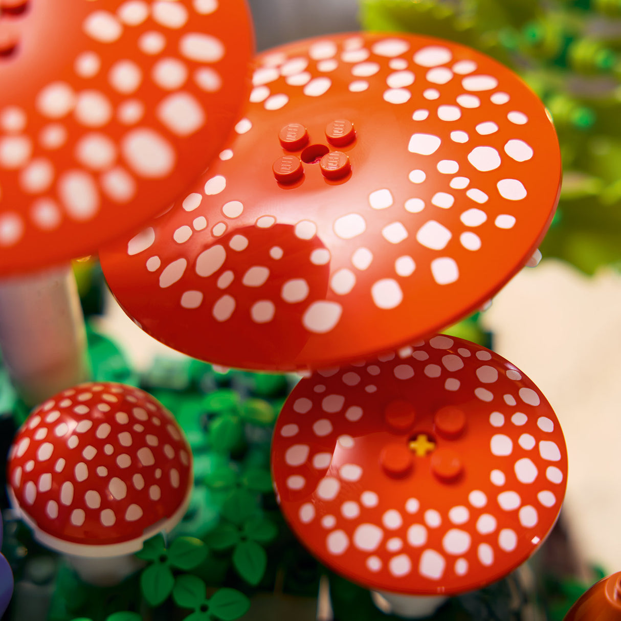 Red and white spotted mushroom-shaped objects with LEGO design on a green background