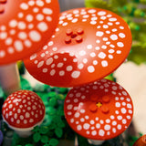 Red and white spotted mushroom-shaped objects with LEGO design on a green background