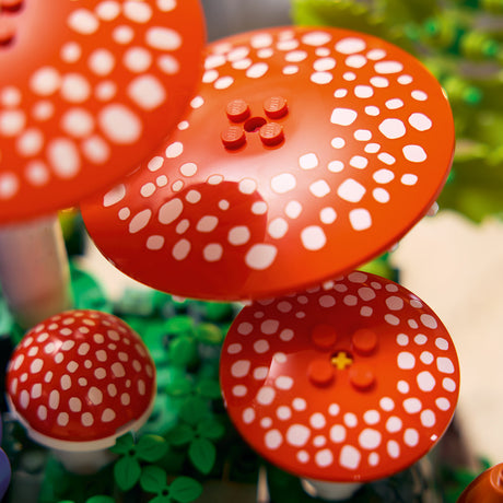 Red and white spotted mushroom-shaped objects with LEGO design on a green background
