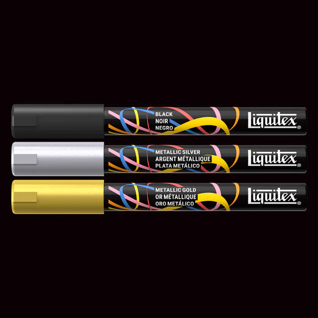 Three Liquitex paint markers in black, silver, and gold on a black background