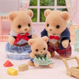 Three teddy bear toys with a baby bear and toys on a soft surface.