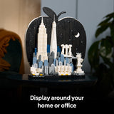 LEGO model of a cityscape in an apple-shaped display case with text 'Display around your home or office'.