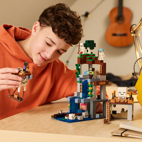 Child playing with a LEGO set on a table, with a guitar in the background.
