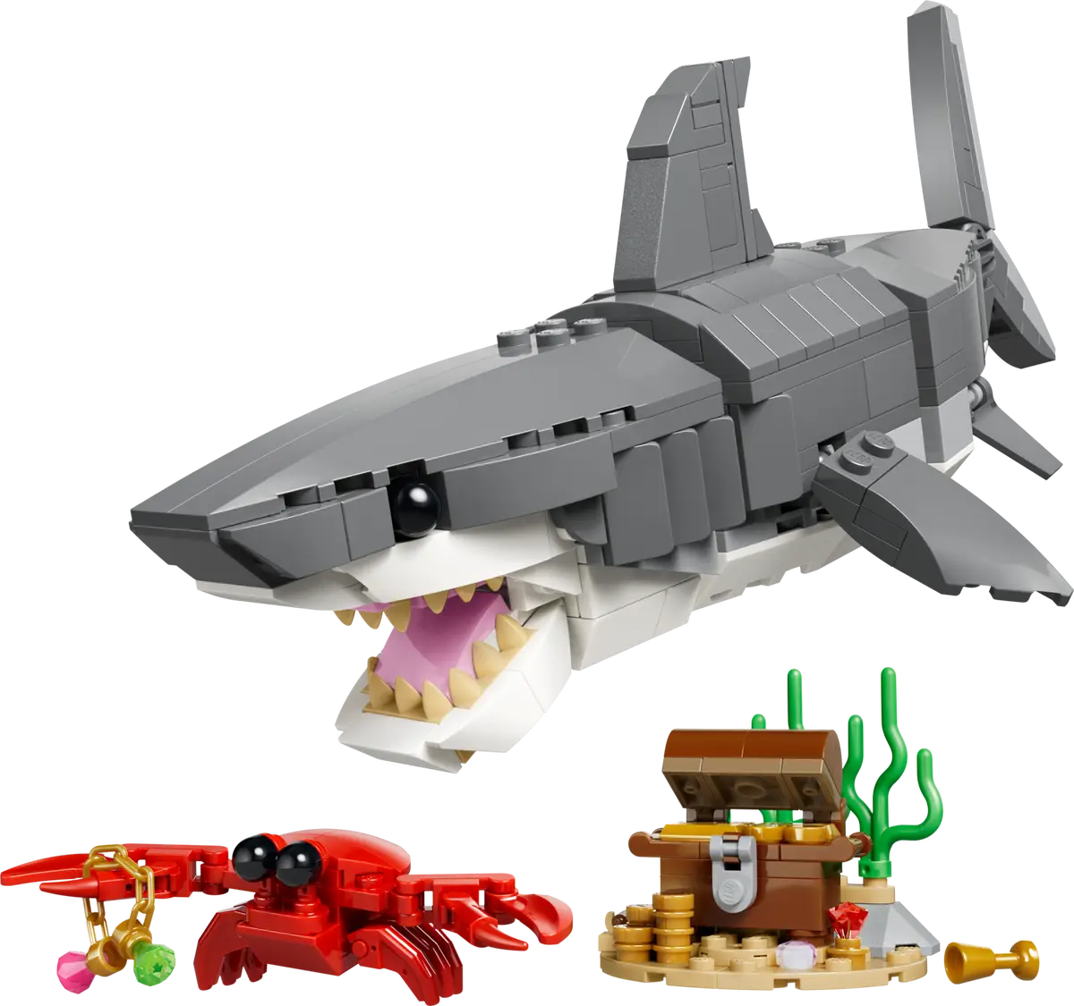 Toy shark model with a crab and treasure chest on a white background