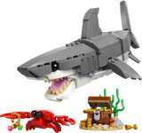 Toy shark model with a crab and treasure chest on a white background
