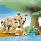 Toy lion figure by a pond with flowers and a tree in the background