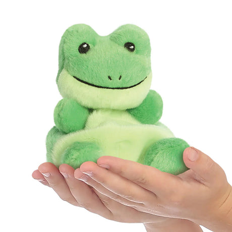 Green plush frog toy held in hands against a white background