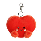 Red heart-shaped plush keychain with a smiling face on a white background
