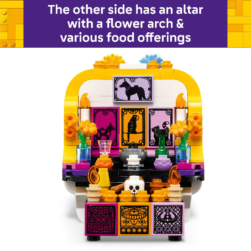 A colorful LEGO Day of the Dead altar building set shown against a white background with a purple text banner at the top describing features like an altar, flower arch, and food offerings.