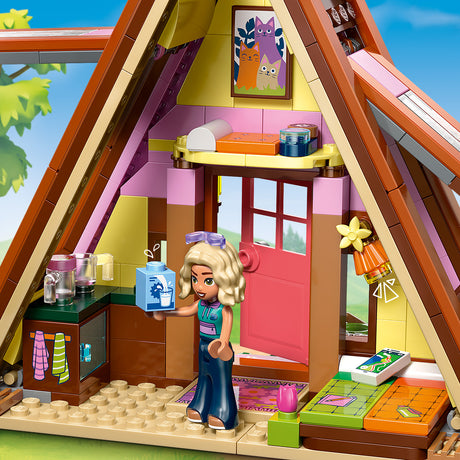 LEGO playset with a girl character holding a box inside a house.