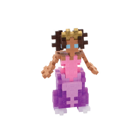 Toy figure made of interlocking bricks with a pink top and purple skirt on a white background