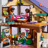 Toy house with a living room and kitchen area, featuring LEGO figures and furniture.