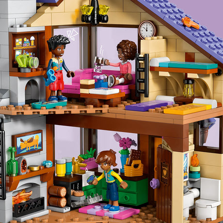 Toy house with a living room and kitchen area, featuring LEGO figures and furniture.