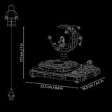 White line-art dimension diagram of a LEGO-style astronaut moon display set on a black background, showing the full height from a minifigure to the top of the display and the base dimensions.
