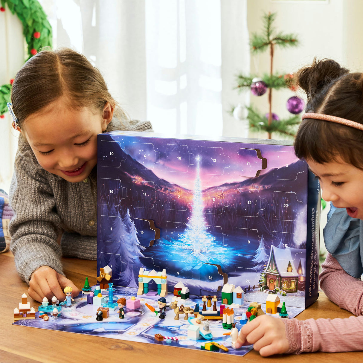 Two children playing with a LEGO Advent calendar on a table.