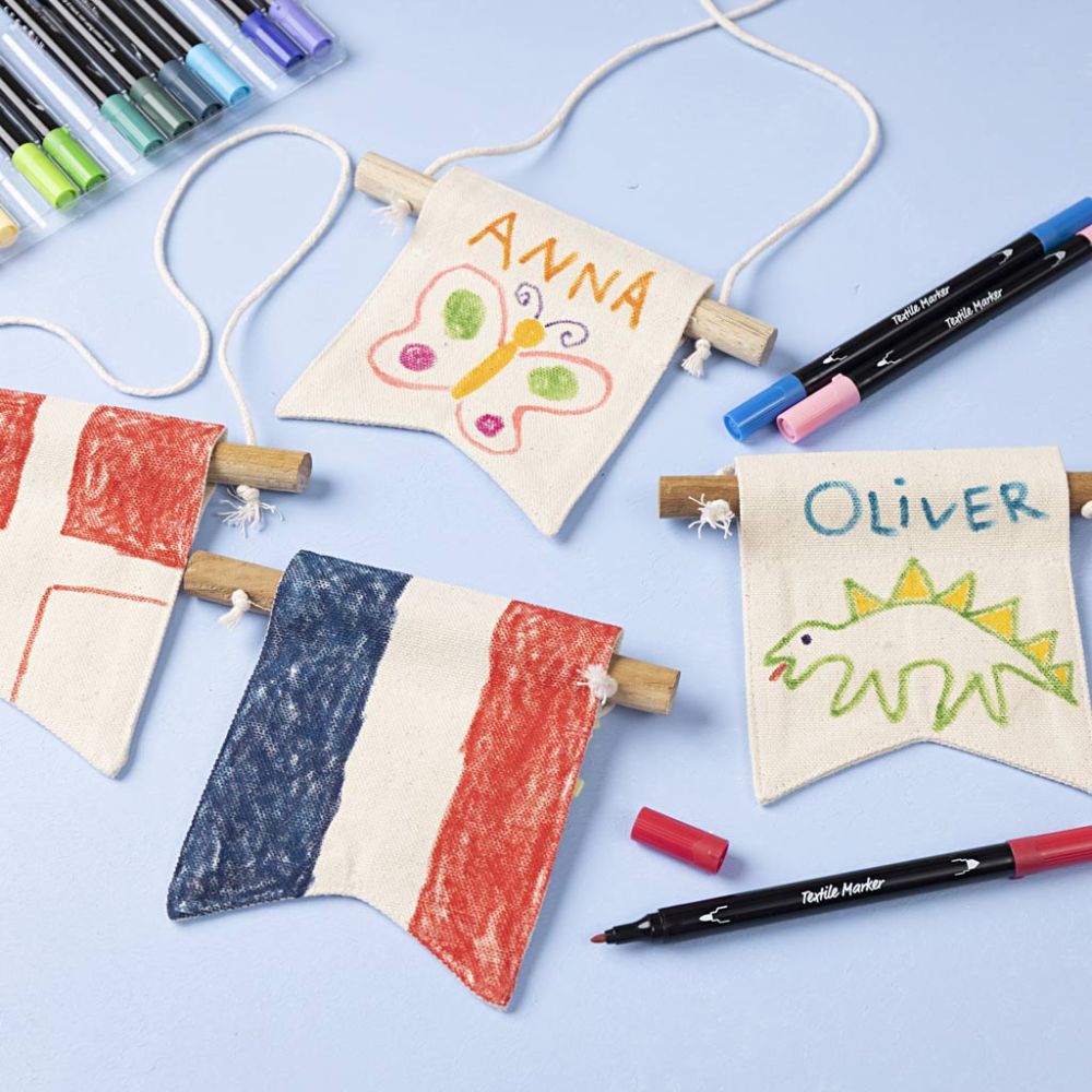 Children's name flags with colorful markers on a light blue background