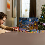 Person interacting with a LEGO Advent calendar in a festive setting with a Christmas tree.
