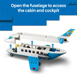 Toy airplane model with open fuselage showing cabin and cockpit, on a blue background.