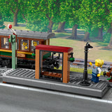 LEGO train set with a station platform and trees in the background