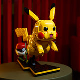 LEGO Pikachu model on a dark surface with a red curtain background