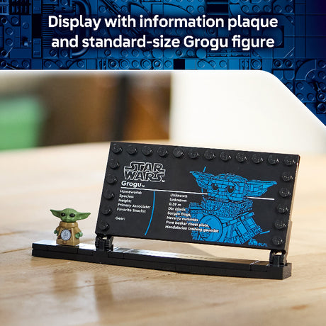 LEGO display with information plaque and standard-size Grogu figure on a wooden surface.