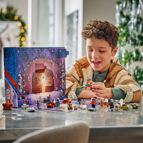 Child playing with LEGO Star Wars set in front of an advent calendar