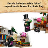 A LEGO-style pirate-themed set shown on a white background with a parchment-style banner at the top reading 'Details include a table full of experiments, books & a pirate flag.' The scene includes two minifigures, a small animal figure, shelves, jars, and a black pirate flag with a skull-and-crossbones symbol.