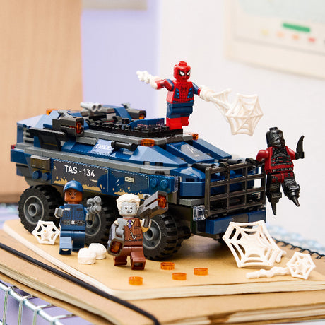 LEGO set with Spider-Man and other characters on a vehicle, on a desk.