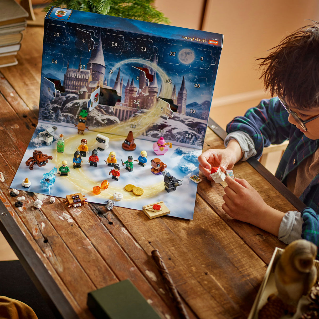 Child playing with a Harry Potter-themed Advent calendar on a wooden table.